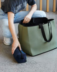 Women putting small neoprene bag into large green neoprene bag