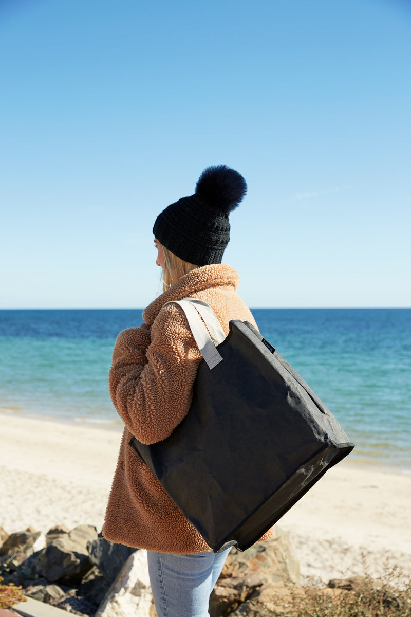 Black coloured reusable bag carried by woman at the beach