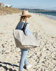 Woman at the beach carrying stone reusable bag