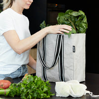 woman unpacking stone colour reusable grocery bag