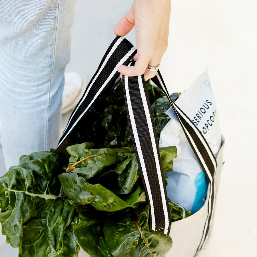 Close up of woman holding reusable grocery bag